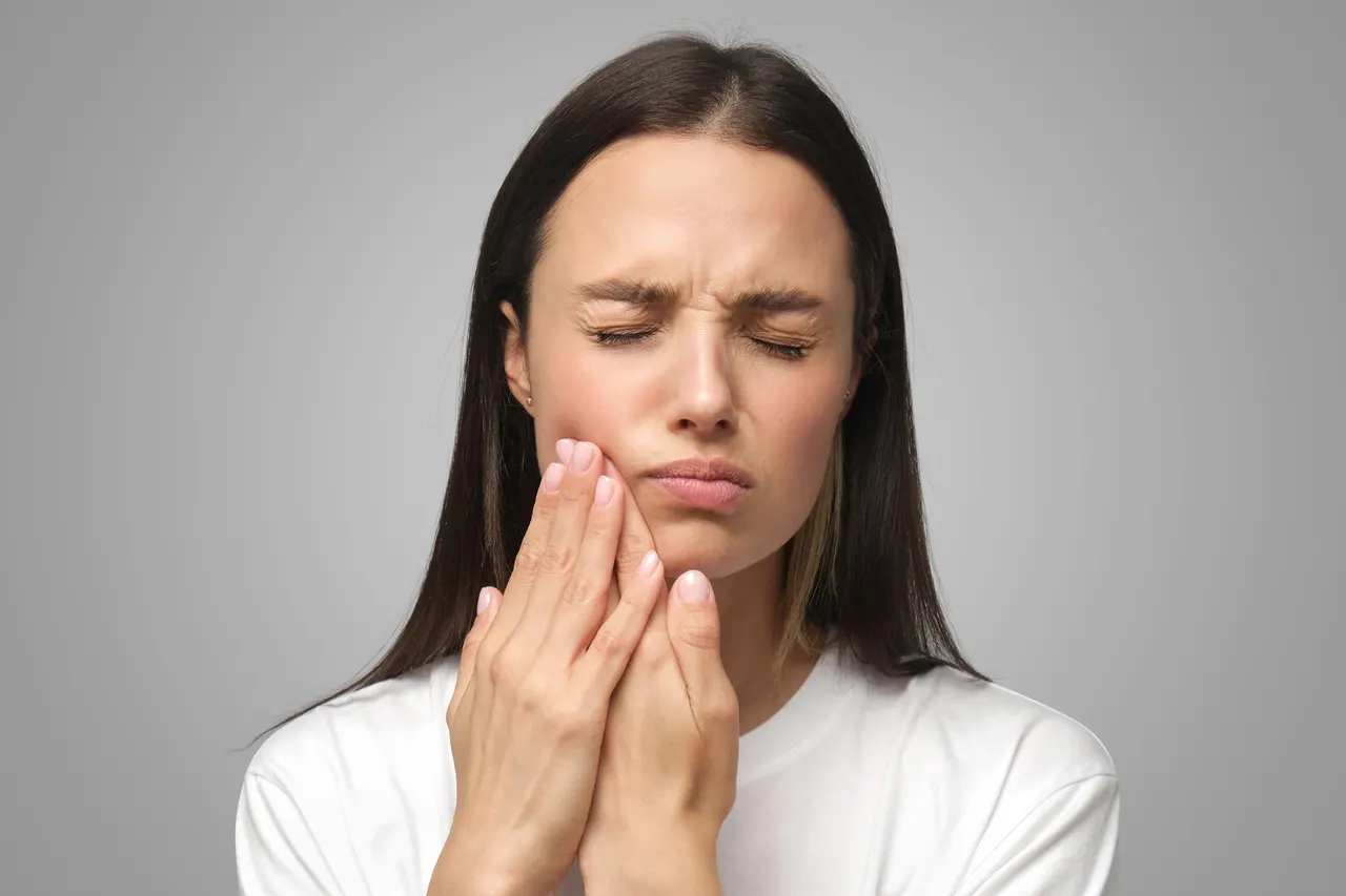Woman holding her jaw in pain from a dental emergency