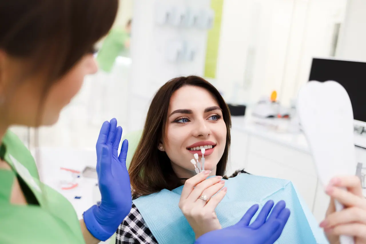 Patient comparing tooth shades with her dentist during a cosmetic consultation